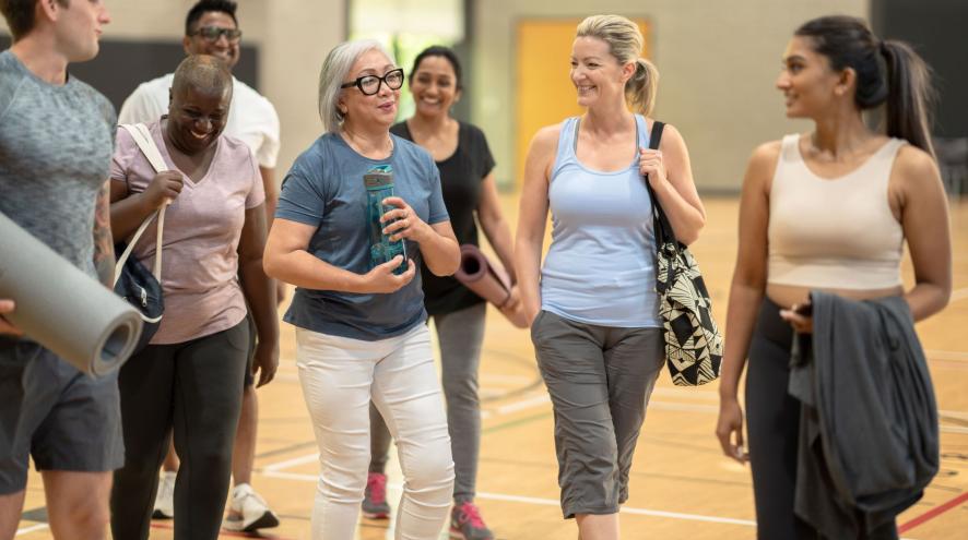 People of multiple ages leaving an exercise class in gym