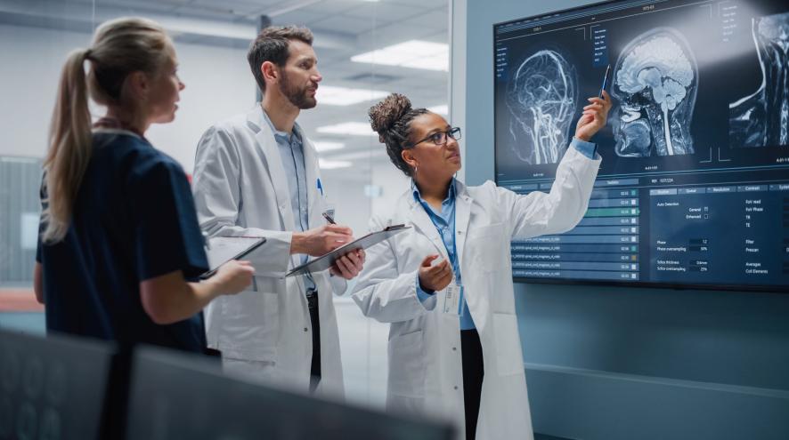 Three scientists discuss a brain scan