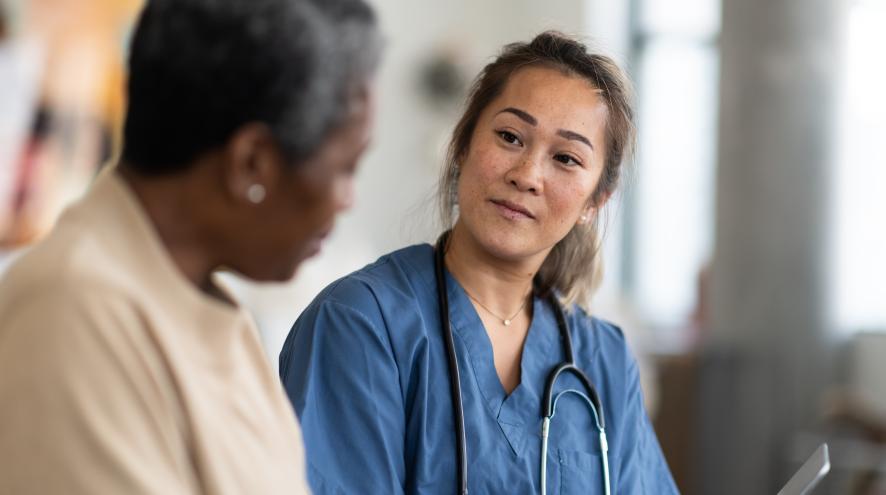 A female medical professional talks to an older woman