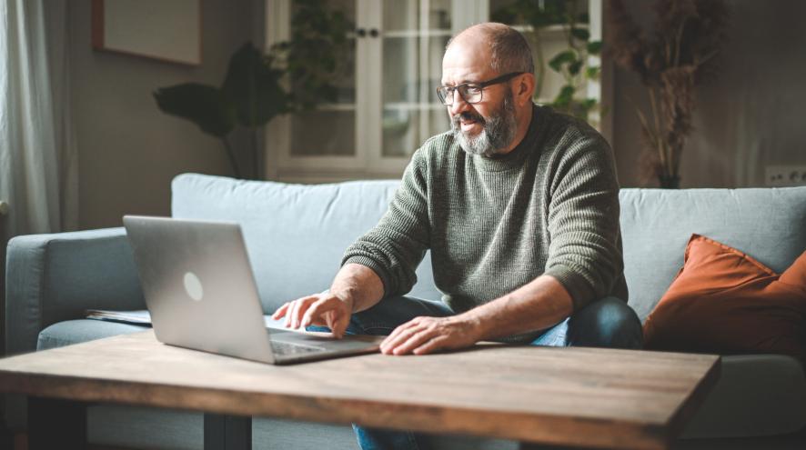 middle-aged man typing on a laptop