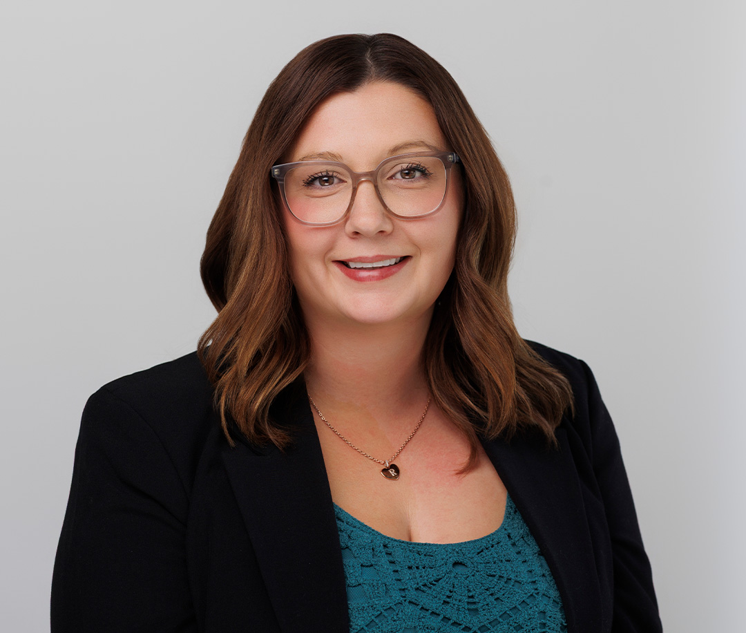 A photo of Rebecca Snider, our Manager of Leadership & Legacy Gifts. She is wearing glasses, a black blazer, and a teal shirt.