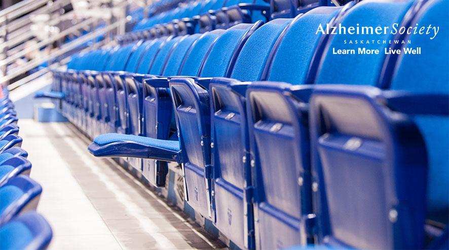 A row of folded arena seats with one seat flipped down in the middle of the row..