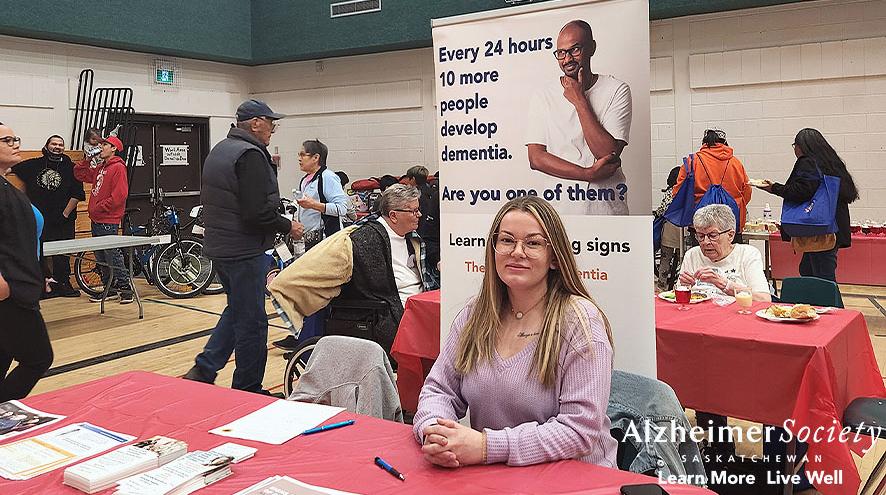 Our practicum student at our information booth with several resources ready to hand out