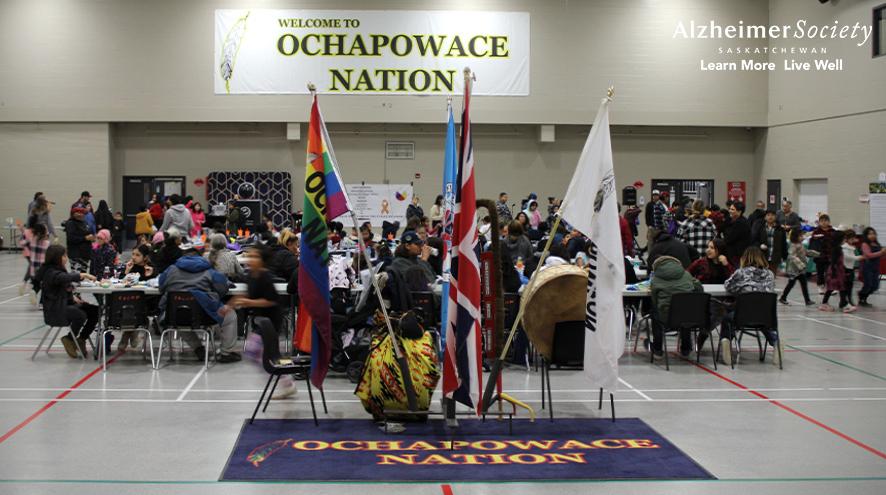 People visiting at tables in the Ochapowace Nation multi-plex.