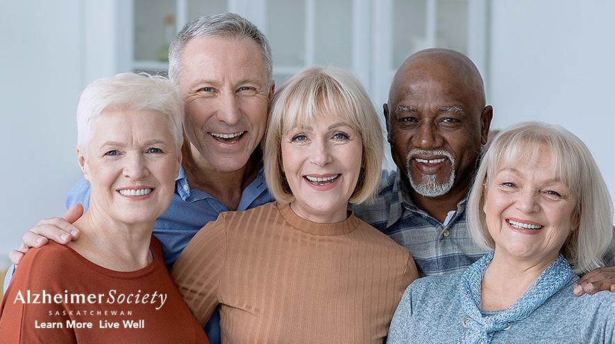 Five people of mixed ethnicities posing and smiling together