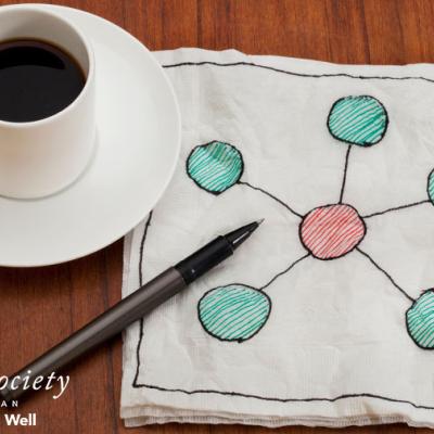 A coffee cup next to a web napkin drawing 
