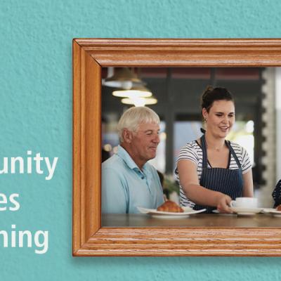 Community Changes Everything text next to a framed picture of a man and a woman enjoying their server's company at a cafe..