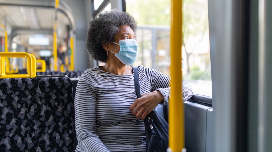Senior woman on a bus wearing a mask.