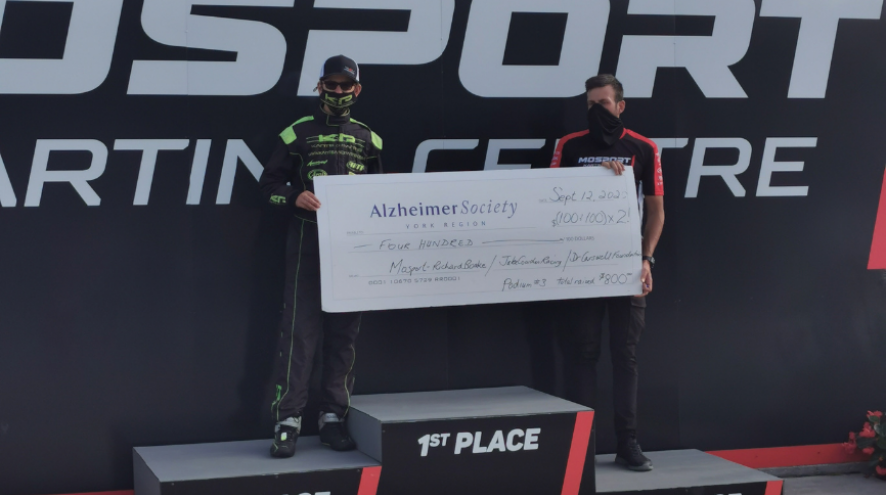 Jake Cowden holding a giant Alzheimer Society of York Region cheque after his recent go-kart win