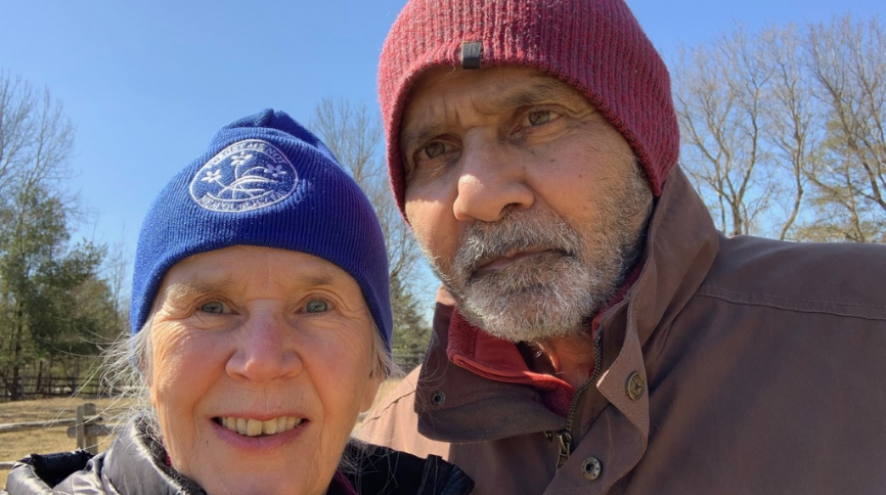 Jennifer Dance Bowen and Feroze outside in a selfie under a blue sky.