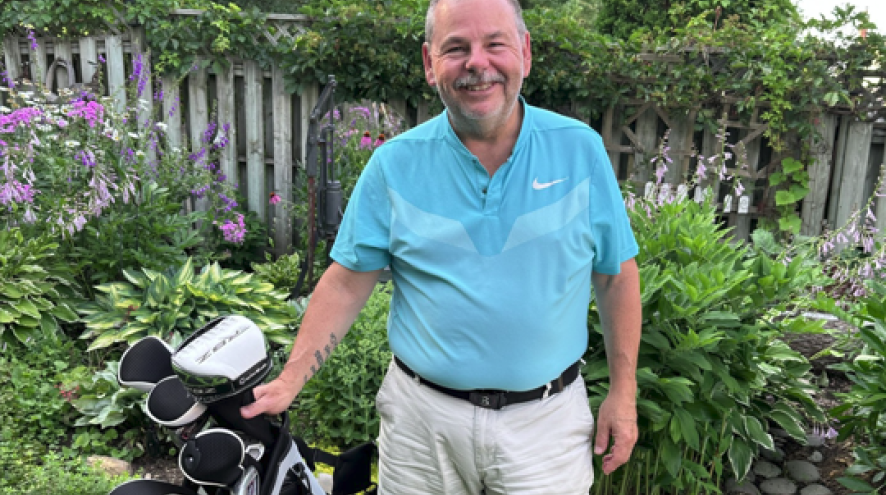 Dave Carrigan poses with his golf clubs.