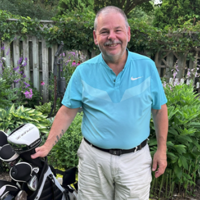 Dave Carrigan poses with his golf clubs.